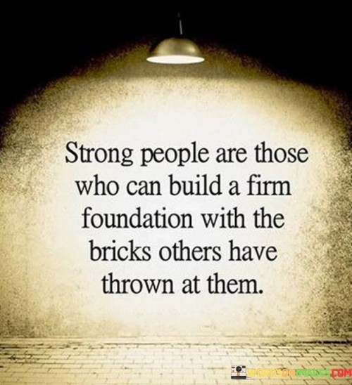 The quote extols resilience as a hallmark of strength. It metaphorically depicts challenges as bricks hurled by others, which the strong skillfully repurpose. Adversities become building blocks for personal growth. Strong individuals, instead of succumbing, ingeniously construct a sturdy foundation from adversity, embodying the power of transformation through adversity.

Strength lies in alchemy of adversity. The quote symbolizes the ability to extract value from negativity. Strong people don't crumble; they harness thrown bricks to reinforce their character. It underscores the capacity to transmute negativity into constructive determination, revealing that strength is born from the mindful handling of life's trials.

The quote evokes the image of resilience rising from turmoil. It celebrates those who convert hardships into stepping stones. It emphasizes that true strength emerges not from avoiding difficulties but from deftly using them to construct a solid base, embodying the art of turning challenges into catalysts for personal fortitude and triumph.